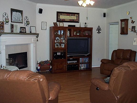 The family room with laminate floor, wood burning fireplace and ceiling fan.