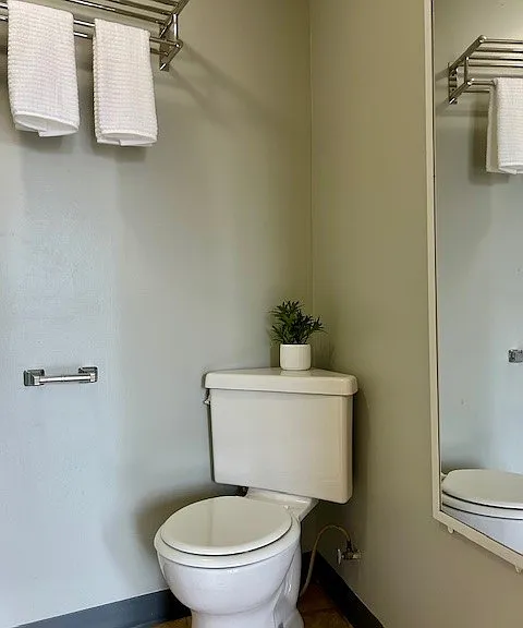 Bathroom comes complete with towel shelf and mirror.