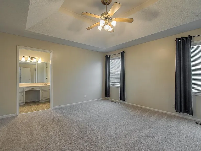 The master features a vaulted ceiling and ceiling fan