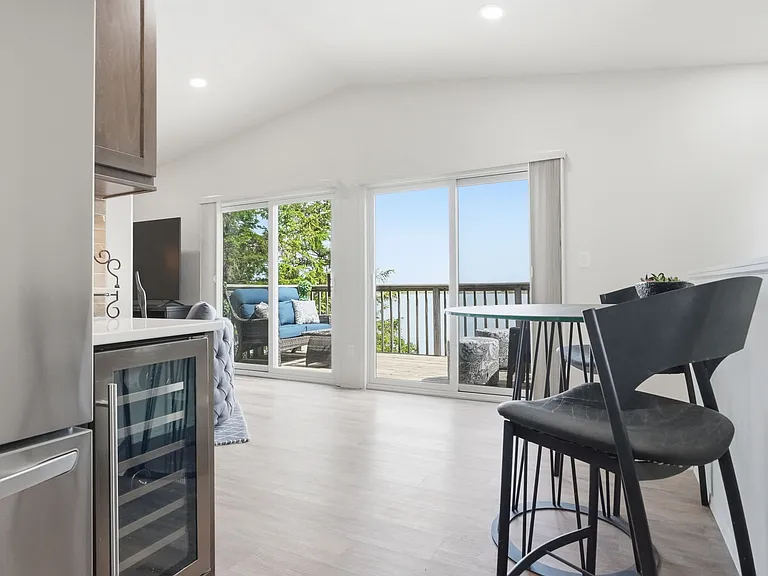 Lake view from kitchen w/ double sliding glass doors & a wine fridge!