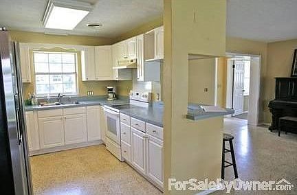 Spacious Kitchen : Complete w/stainless fridge, icemaker, bar area and plenty of storage.