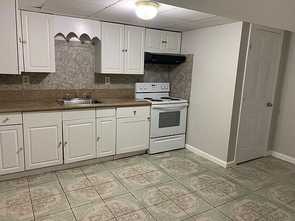 Kitchen with White cabinets and brand new stove.