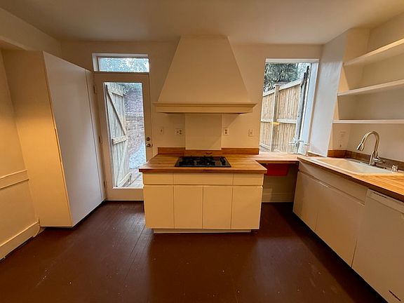 Kitchen: pantry to the left of the door Sink to the right of the center gas stove top.