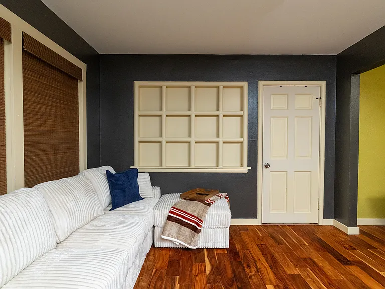 Open and inviting living room featuring a cozy couch, a ceiling fan for comfort, and fun colors that add character and flow.