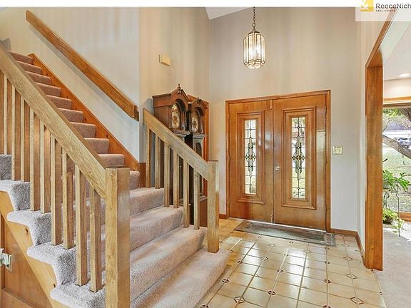 This light and bright entryway has soaring ceilings and gorgeous double doors.