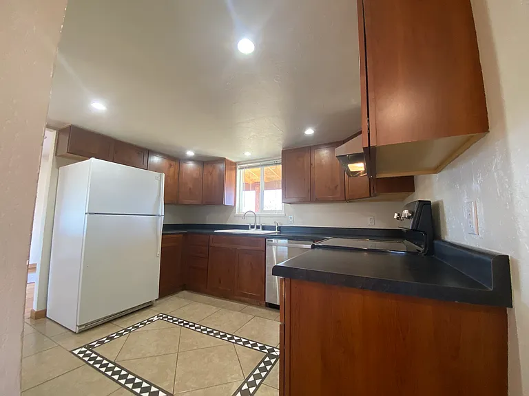 Functional kitchen featuring ample cabinet storage, generous workspace, and included appliances for everyday convenience.