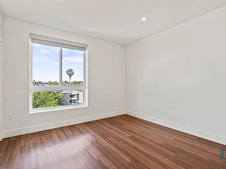 Bedroom with Large-Size Windows, Vinyl Flooring, and Mirrored Closet