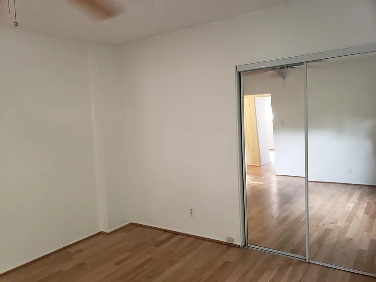 This is a view of the mirrored closet door in this nice size bedroom, smooth ceiling, forced air and ceiling fan and natural light