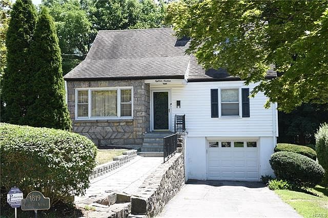 Charming stone & vinyl sided cape cod home.  New walkway and stone wall.