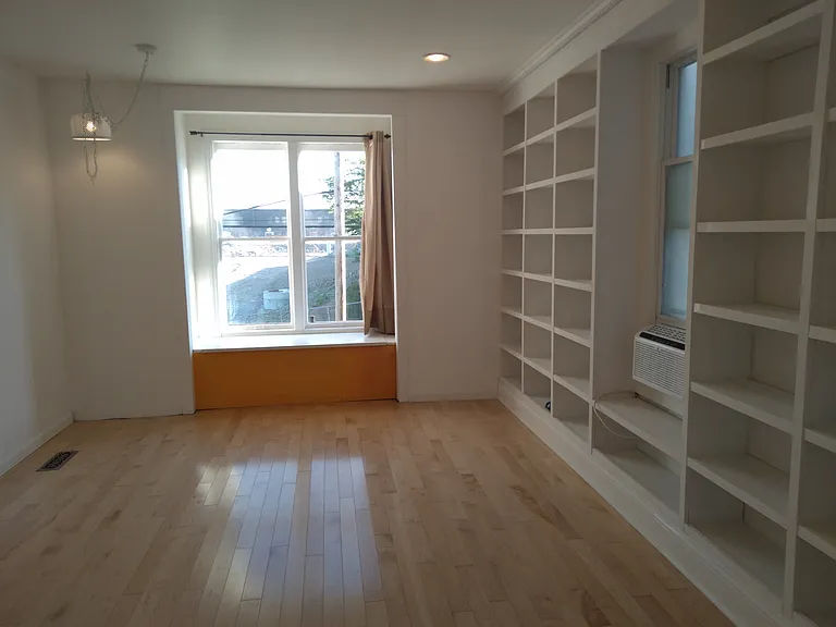 View of the living room bookshelves and bay window out to 2nd Ave.