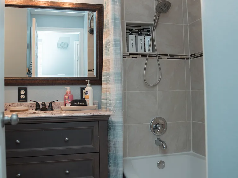 Clean and bright bathroom with a convenient wood-toned storage cabinet for all your essentials.
