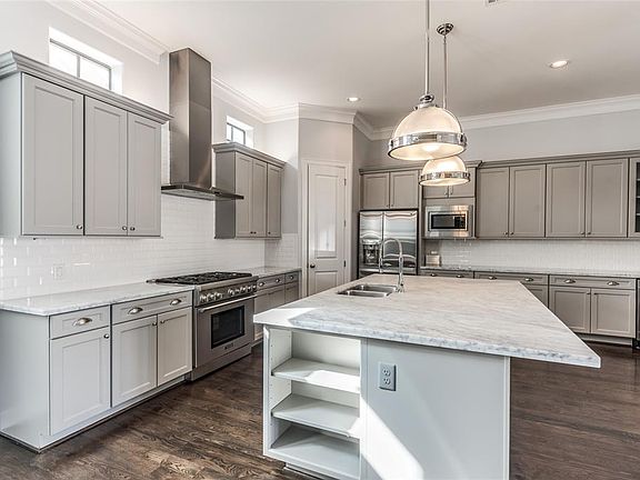 The fabulous Chef's Kitchen is one of the highlights of this home! Custom cabinets painted gray offer amazing storage. Marble countertops with subway 
