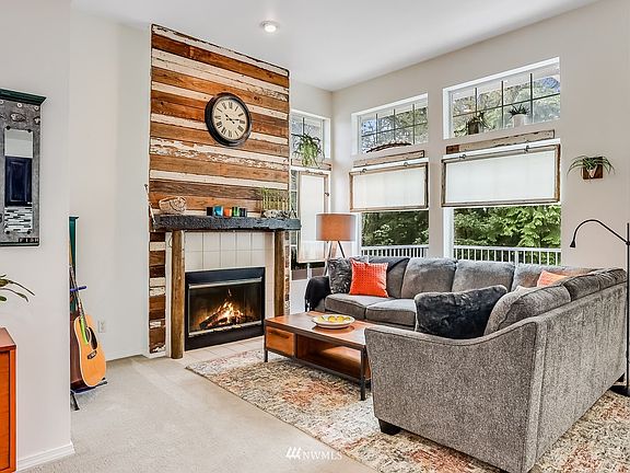 Warm & cozy Family Room features a wood burning fireplace and a wall of oversized windows to let in that coveted natural light.