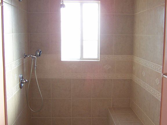 Limestone shower with bench for warm showers