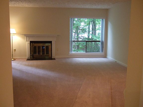 Great Room with fire place and entry to deck with wooded view