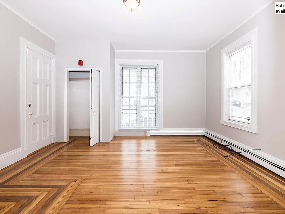 Bedroom (door on left is the private entry into bedroom from front hall). Large windows, closet, high ceiling, lots of natural light and refinished hardwood floors.