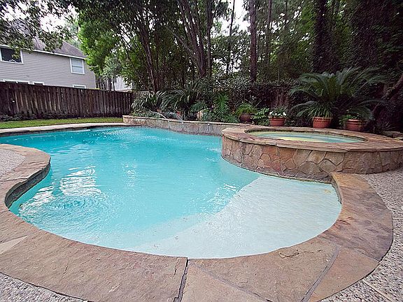 Another view of the pool with the sprinkler waterfall and foliage.