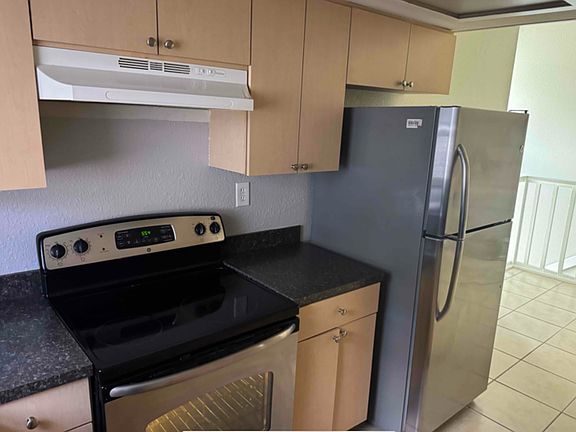 Fully equipped kitchen with large stainless steel refrigerator and stove.