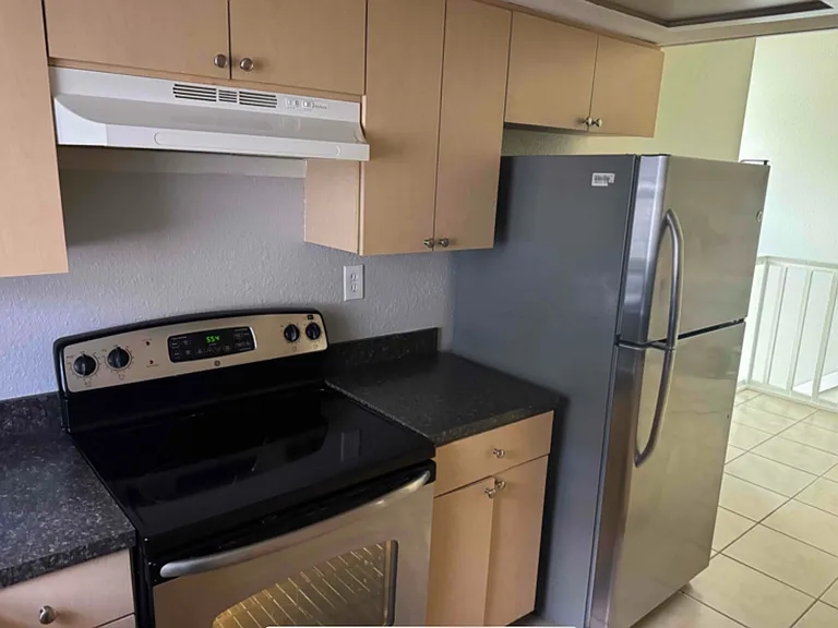 Fully equipped kitchen with large stainless steel refrigerator and stove.