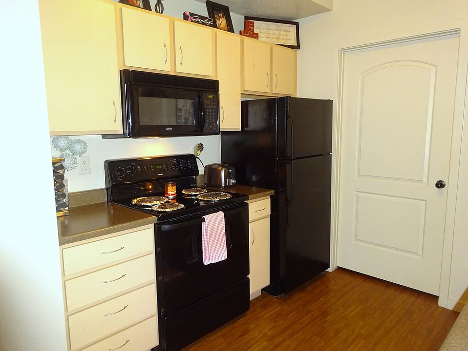 Black appliances and hardwood floor in the kitchen. The door