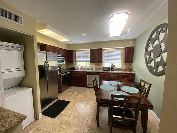 Fully equipped kitchen features granite counter tops, stainless steel appliances and stacked washer/dryer. Dining table seats 4