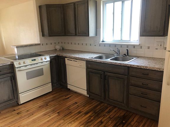 Nice kitchen with custom tile backsplash, slide in range, dishwasher, refrigerator and clothes washer and dryer nearby