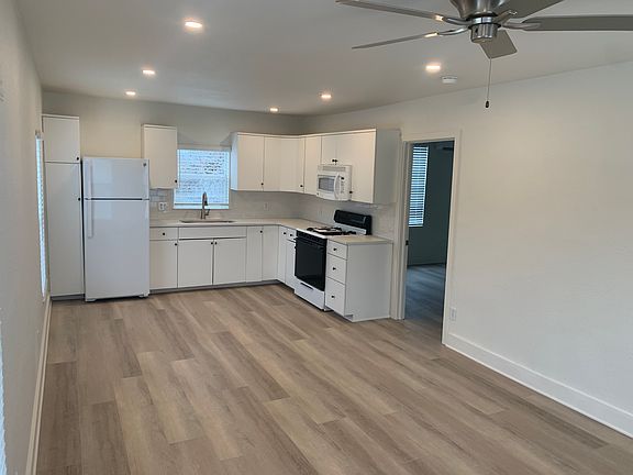 View of kitchen and bedroom door from corner of living area