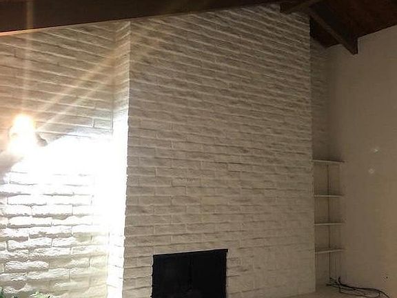Living Room with raised fireplace and high Cathedral ceiling throughout unit.