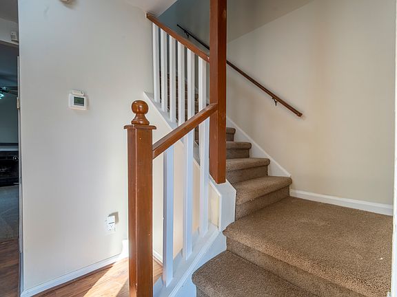Entryway and stairwell with carpeted stairs and access to the main living areas.
