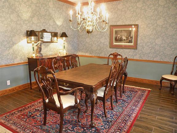 Formal dining area with wood like tile flooring, chair molding, crown molding and fluted cased opening