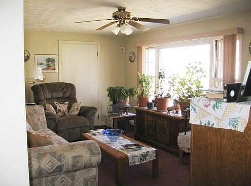 Sunny formal living room with hardwood under wall to wall