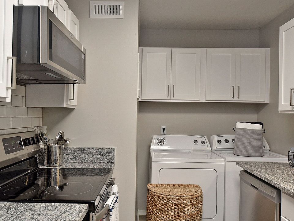 Kitchen with granite counters, washer & dryer, modern cabinetry, and stainless appliances