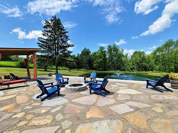 Stone patio and firepit overlooking large pond