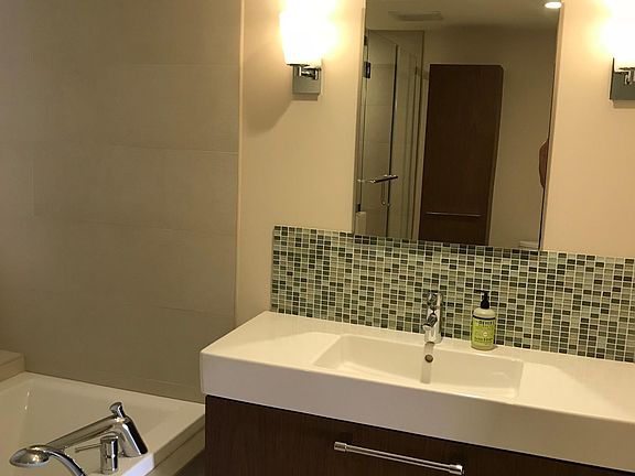 Bathroom vanity with 2 person tub on the left.