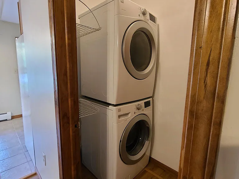 Upright washer and dryer with crawl space storage access underneath