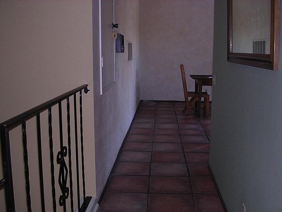 Italian tiled hallway that is leading to large kitchen that has view of mountains.