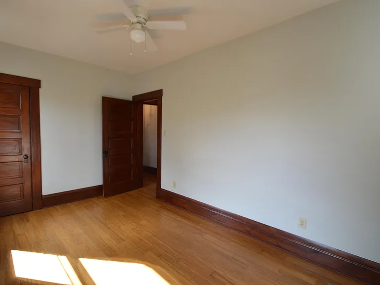 Generous closet space in bedroom 2 with neutral paint and bamboo floors. New ceiling fan installed in 2025 (not pictured).