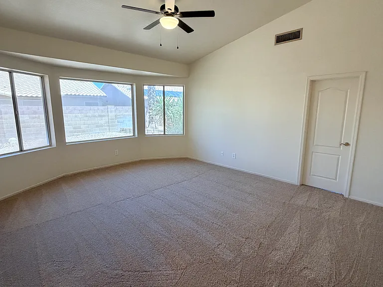 spacious primary bedroom featuring 
bay-style windows and an open, airy feeling