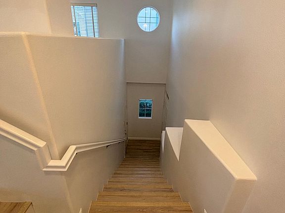 View from the landing looking down the main entrance stairs. The front door is on the right and the garage door is on the left