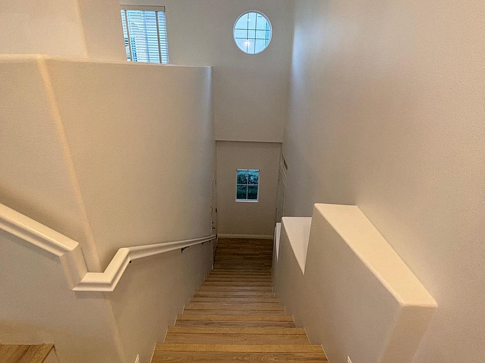 View from the landing looking down the main entrance stairs. The front door is on the right and the garage door is on the left