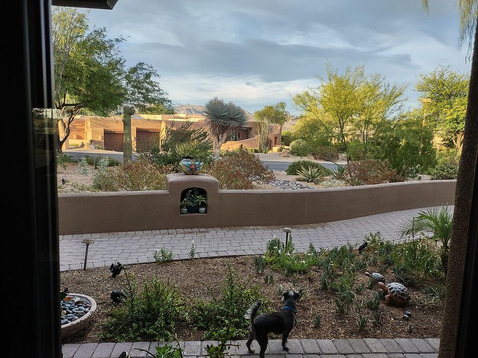 View from kitchen window to home across the street with sunrises over mountains