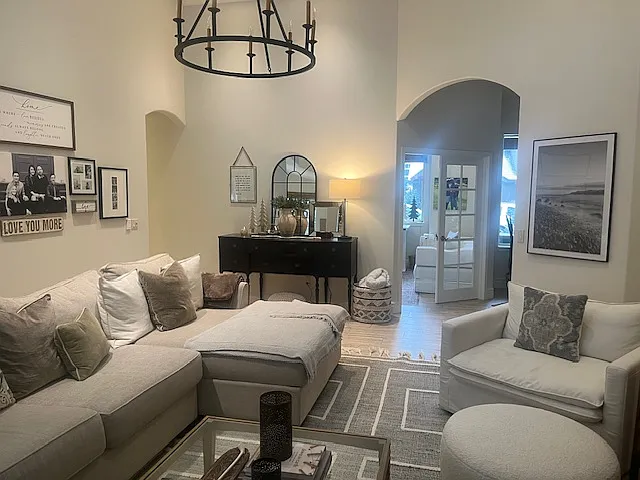 Living Room with previous tenants' furnishings. View to entry and office.