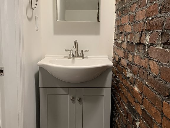 First floor bathroom with a restored brick accent wall!