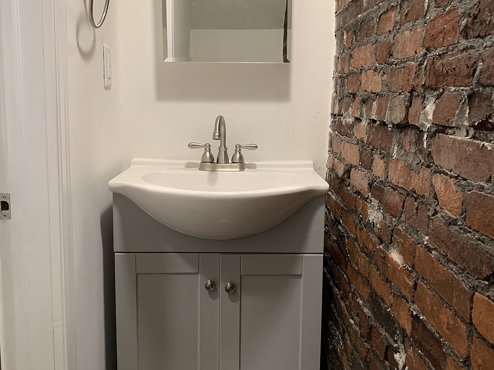 First floor bathroom with a restored brick accent wall!