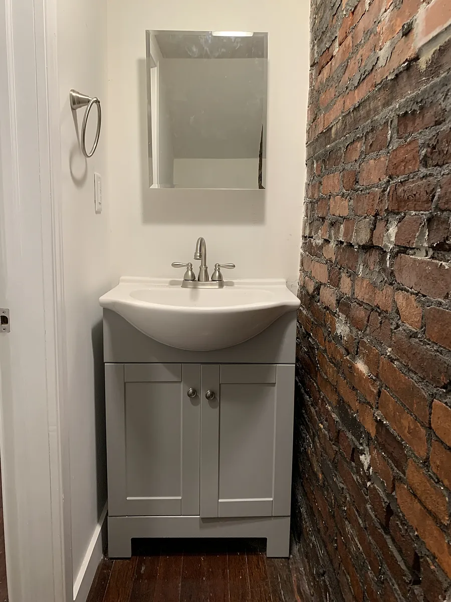 First floor bathroom with a restored brick accent wall! - 326 Walnut St