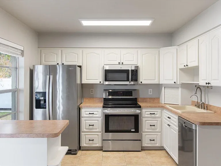 U-shaped kitchen with ample cabinet storage, stainless steel appliances, and generous counter space with a peninsula.