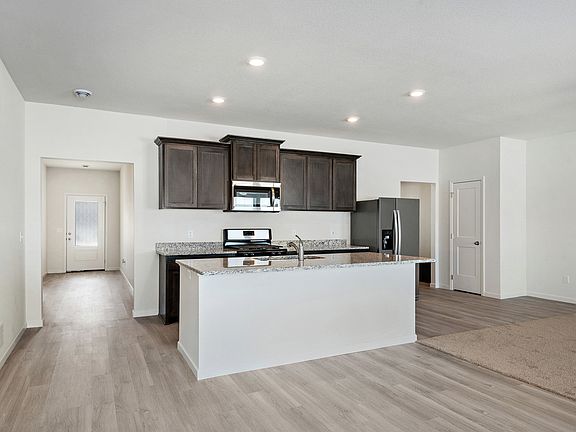 The kitchen has a large island that overlooks the entertainment space