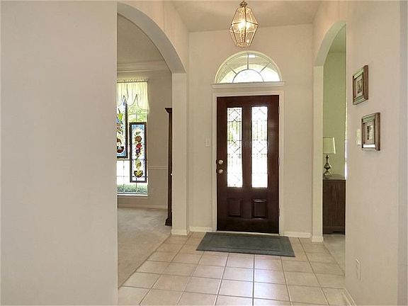 Wide, tiled entry has high ceiling and arched transom window!