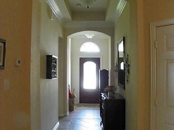 The long entry boasts high ceilings, custom tile-work, and crown molding.