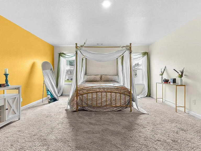 Unwind in a spacious master bedroom featuring a gorgeous accent wall and ample natural light. The attached master bath is a true oasis, complete with a deep soaking tub, a separate shower, a beautiful modern accent tile wall, and built-in shelving.